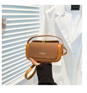 Détail du sac cylindre en cuir caramel avec rabat tressé et fermoir doré chic