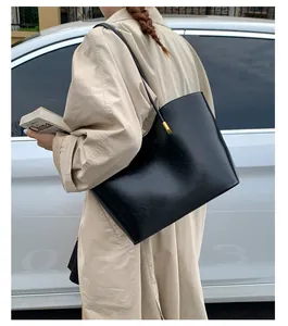 Détails du sac cabas en cuir noir avec ferrures dorées et bandoulière réglable chic