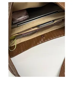 Interior detail of a brown woven leather tote bag showing large capacity and compartments