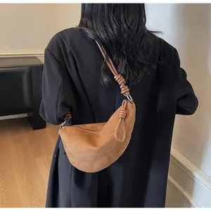 Détail d'un sac hobo en daim marron avec bandoulière nouée dans un cadre de style urbain