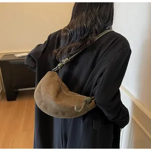 Gros plan sur le sac hobo en daim marron avec bandoulière nouée et forme de croissant