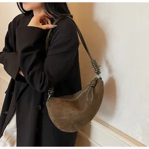 Détail d'un sac hobo en daim marron avec un design de bandoulière nouée distinctif