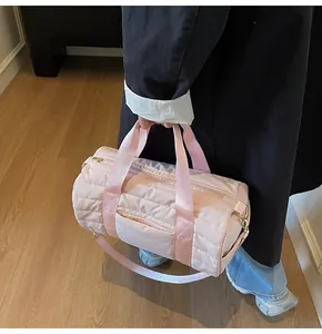 Detail of pink quilted cylindrical bag showing nylon texture and gold hardware