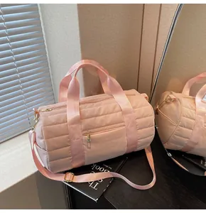 Detailed view of pink quilted duffel bag with gold hardware and adjustable strap