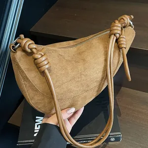 Sac hobo en daim marron avec bandoulières à double nœud et design minimaliste à fermeture