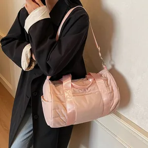 Pink quilted cylinder travel bag with adjustable strap and top handles for fitness