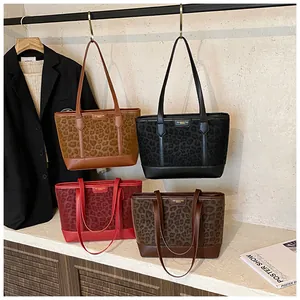 Close-up of leopard print patchwork tote bags in four colors with metal logo detail