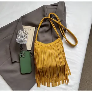 Détail du sac bandoulière en daim jaune avec de longues franges bohèmes et fermeture éclair