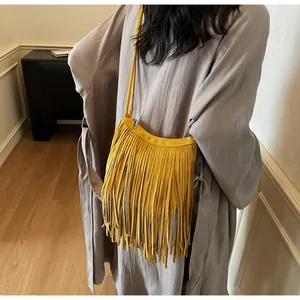 Vue détaillée du sac bandoulière en daim jaune avec de longues franges denses et une sangle