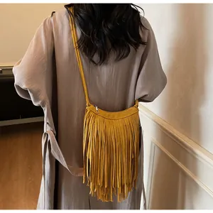 Détail du sac à bandoulière en daim jaune avec franges et fermeture éclair argentée