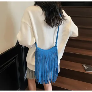 Détail du sac bandoulière bleu vif avec de longues franges et texture suédée
