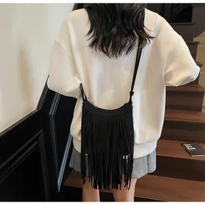 Gros plan du sac bandoulière noir à longues franges pour un style urbain et chic