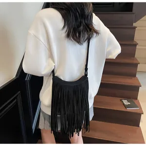 Détail des longues franges noires et de la texture douce sur ce sac à bandoulière