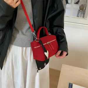 Petit sac bandoulière rouge en daim avec breloque cœur et double fermeture éclair chic