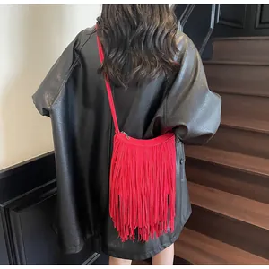 Détail du sac à bandoulière à franges rouges sur un mannequin en veste de cuir