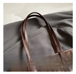 Detail showing high-quality dark brown leather handles and leopard print texture on tote bag