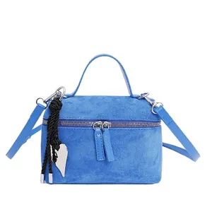 Sac à main boîte en daim bleu roi avec poignée et pendentif cœur vu sous un angle frontal