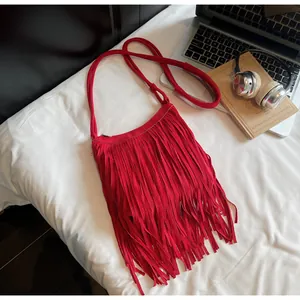 Vue détaillée du sac bandoulière rouge en daim avec longues franges et fermeture éclair