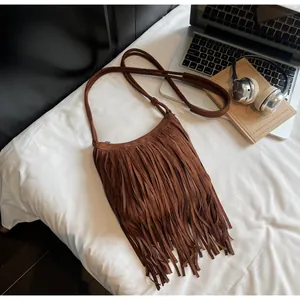 Vue de dessus d'un sac bandoulière en daim marron avec détails de franges bohèmes chic