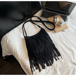 Vue de dessus d'un sac bandoulière noir à franges de style bohème avec longues anses
