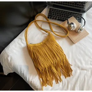 Sac bandoulière jaune à franges en daim avec ordinateur et casque en vue de dessus