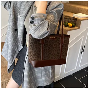 Brown leopard print tote bag with dark leather handles shown in a lifestyle setting