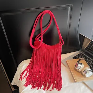 Red faux suede crossbody bag with vintage tassel detail and curved zipper design