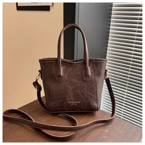 Close-up of dark brown vintage tote bag with marble texture and golden hardware