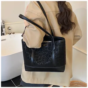 Detail of large leopard print tote bag styled with a modern trench coat for women