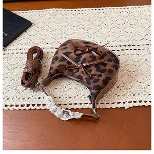 Detail of leopard print mini crescent bag with brown bows and white lace handle