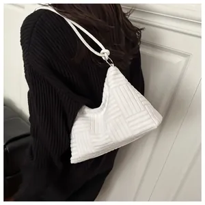 Detail view of the white woven texture and metallic rings on this large hobo tote bag