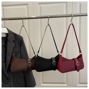 Three retro suede shoulder bags in brown, black and burgundy with silver ring buckles