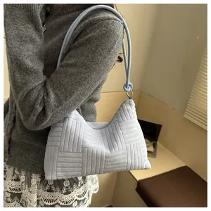 Close-up of light blue hobo bag with geometric 3D texture and metallic ring detail