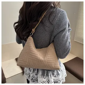 Detail of checkered tote bag with woven texture and decorative knot strap on shoulder