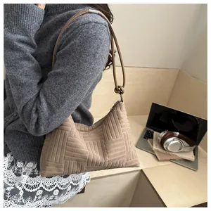 Detail of checkered texture on a large khaki tote bag with knot strap and silver ring