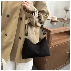 Detail of black geometric quilted hobo bag featuring double straps and crescent shape