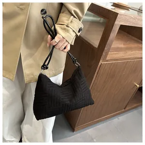 Detail of black woven corduroy tote bag with metallic rings and slim handle strap