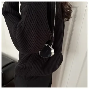 Mini sac à bandoulière octogonal en cuir verni noir porté sur l'épaule