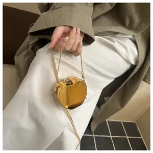 Détail d'un mini sac coeur doré métallisé avec finition miroir polie et chaîne perlée