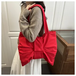 Nahaufnahme der roten Oversize-Schleifentasche am Modell mit detaillierter Stoffstruktur