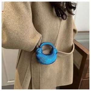 Détail du mini sac coquillage bleu en acrylique avec texture spirale et chaîne dorée