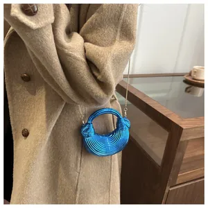 Détail du sac à main bleu électrique à rayures spirales avec fine chaîne dorée