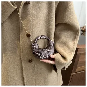 Détail d'un sac demi-lune métallisé avec texture plissée et bandoulière dorée