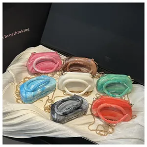 Detail shot of multi-color marble acrylic evening clutches with curved top handles