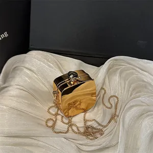 Sac pochette doré brillant avec fermoir en pierre précieuse et chaîne sur soie