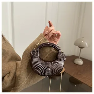 Vue détaillée du sac coquille marron avec plis radiaux et bandoulière chaîne dorée