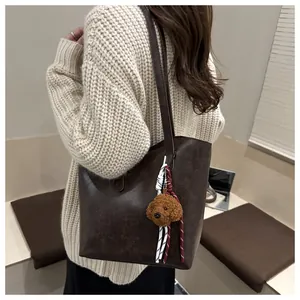 Détail du grand sac cabas marron avec breloque chien en peluche et cordon tressé