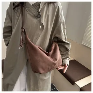 Close-up of brown suede hobo bag texture and leather strap detail for women