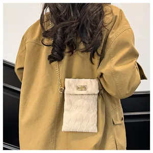 Detailed back view of a beige quilted velvet chain bag on a model wearing khaki coat