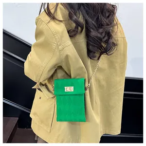Detail of green velvet quilted mini bag with gold chain strap on khaki jacket